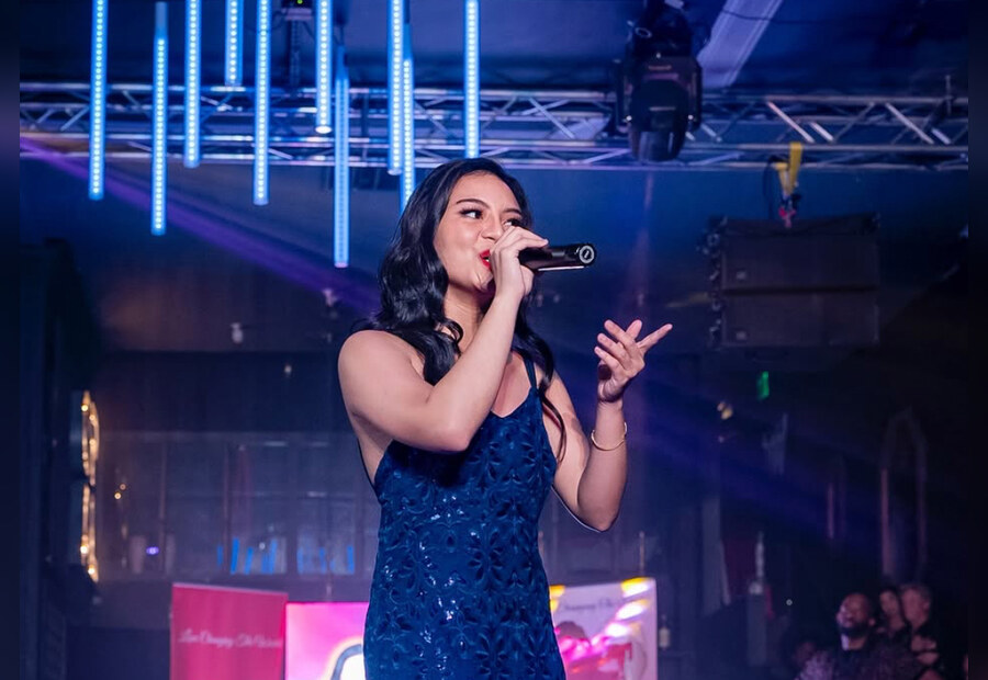Vocalist performing onstage under blue lights