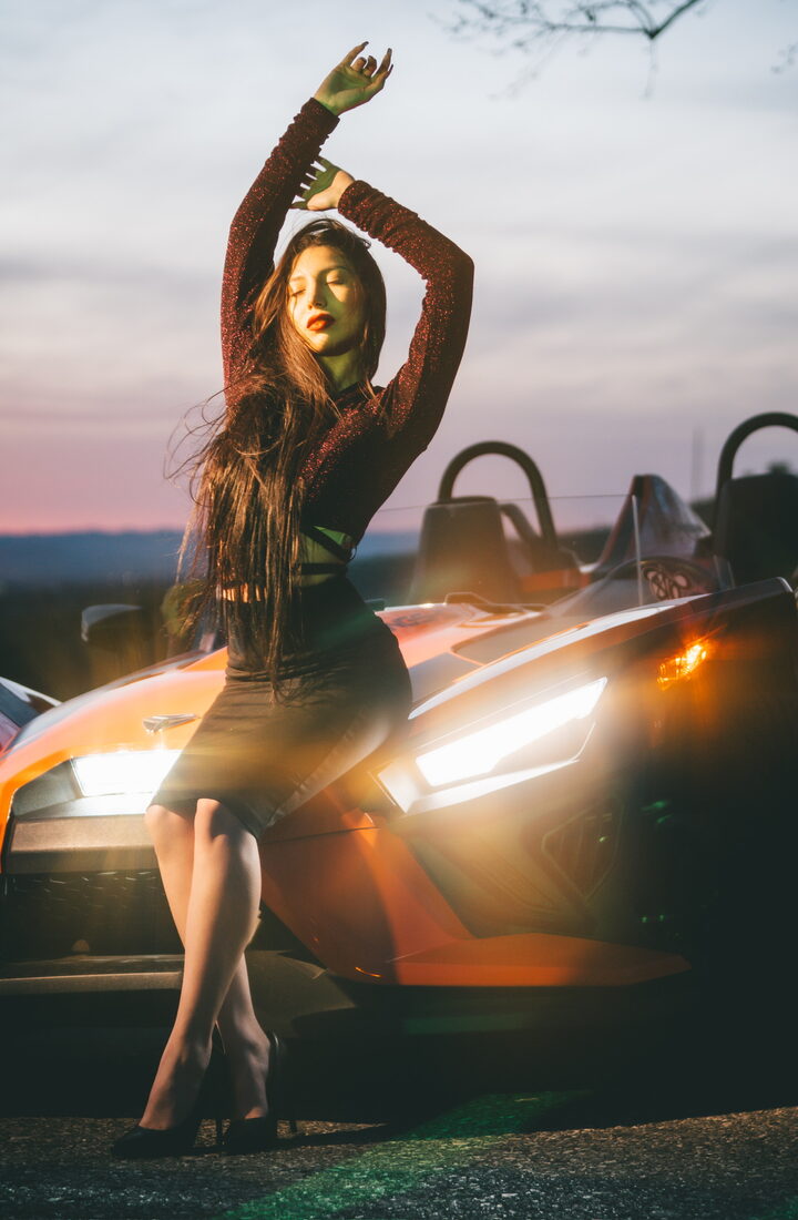 Fashion portrait beside a car at dusk
